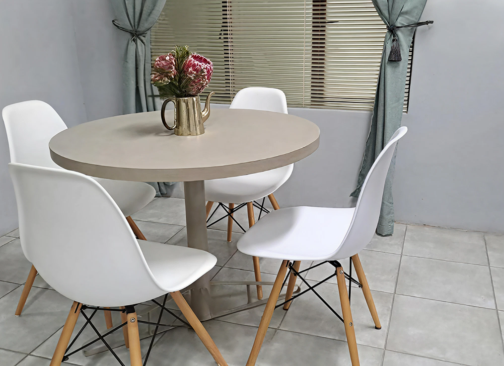 Dining nook with round table and protea flowers