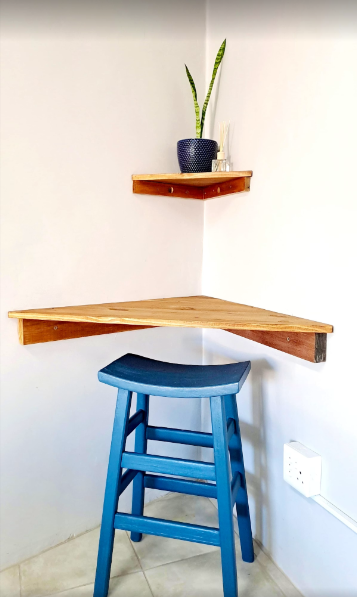 Corner seating area with wooden shelf and blue stool