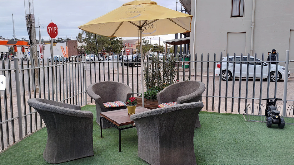 Outdoor patio with umbrella and tub chairs